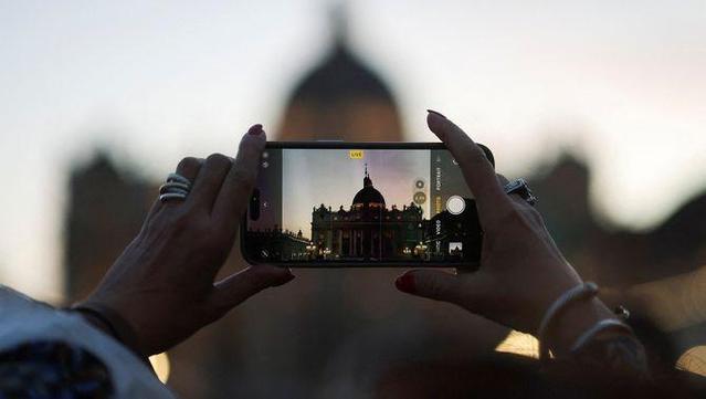 Un mòbil fotografia la plaça de Sant Pere del Vaticà (Reuters)