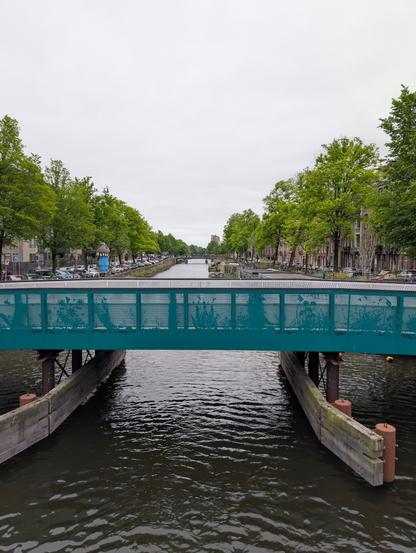 View of a canal in Amsterdam from a bridge, directly in the center of the canal