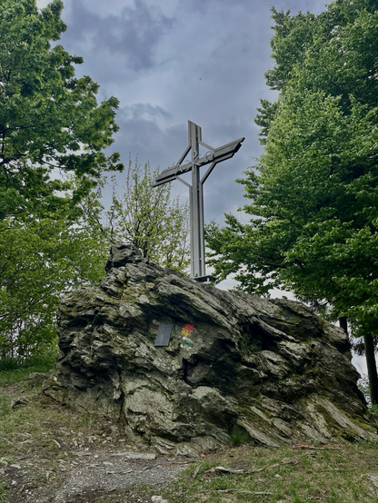 Gipfelkreuz des Geschriebensteins als Felsen und grünen Bäumen rundum