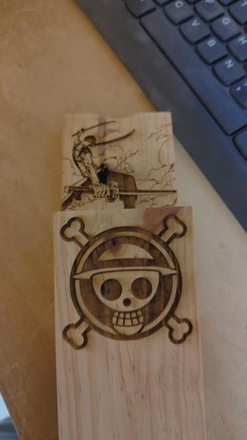 deux morceaux de bois sur lesquels sont gravés le logo est une image du manga One Piece