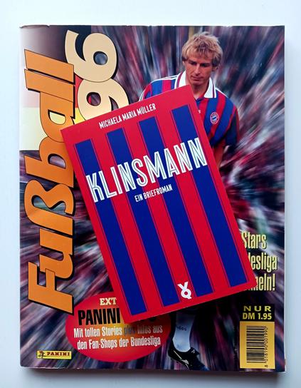 Foto des Buches, dessen Cover in geraden dunkelblauen Balken auf rotem Grund dem Trikot des FC Bayern München nachempfunden ist. Das Buch liegt auf dem Panini-Sammelheft »Fußball 96« zur Bundesliga. Auf dem Cover ist Jürgen Klinsmann in ebendem Bayern-Trikot zu sehen, das das Cover aufgreift. 
1996 hatte Michaela ihre Klinsmann-Verehrung weitgehend abgelegt, aber ein entsprechendes Heft vom Ende der Achtzigerjahre, als Klinsmann noch für Stuttgart spielte, fand sich im Lektorinnenhaushalt nicht.