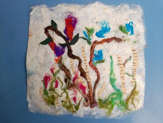 Handmade silk paper (made from stil gummed raw silk gossamer) with inclusions and applications of coloured silk straps, old book paper and coloured spun silk threads. It looks like a meadow with flowers.