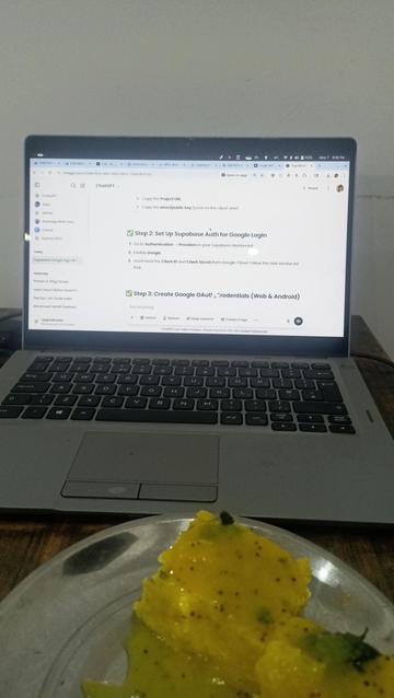 My laptop screen with a chatGPT tab open, along with tasty dhokla (Indian dish)