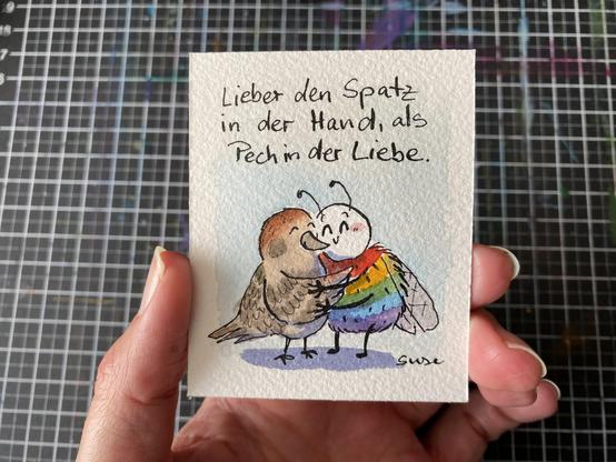 "Lieber einen Spatz in der Hand, als Pech in der Liebe." Ein Spatz, der die Pupsbiene umarmt. Die Pupsbiene ist eine Regenbogenfarbene Hummel.