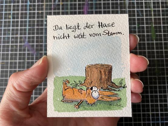 "Da liegt der Hase nicht weit vom Stamm.
Ein Baumstumpf, vor dem ein Hase auf dem Rücken liegt.