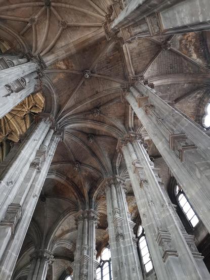 Le chœur de l'église Saint Eustache, vu en contre-plongée : des voûtes sur croisées d'ogives, supportées par des piliers Renaissance, avec des colonnettes superposées.