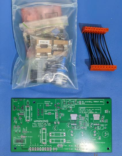 A Dragon 32 replacement power supply kit PCB, unpopulated, with components nearby.