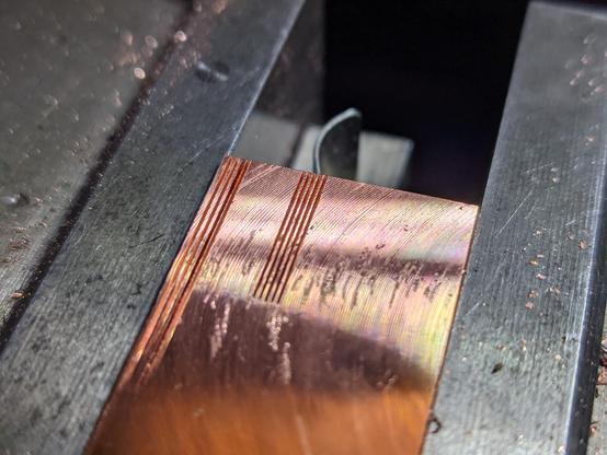 closeup of a copper scrap piece, 0.2mm slits are cut into the surface with 0.2mm spacing