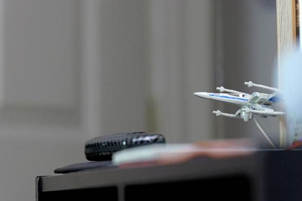 A toy X-Wing on a stand.