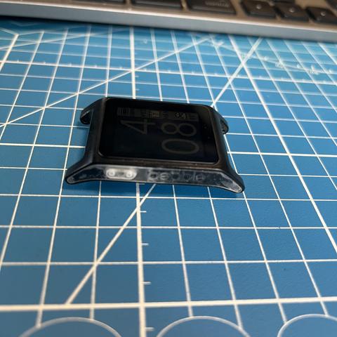 The image shows a black smartwatch with a square face, placed on a blue cutting mat with a grid pattern. The watch displays the time "08:44" in large, bold numbers on the screen. Below the time, there are smaller icons and text, including a weather icon, the day "Wed," and the date "7/50." The watch has a black bezel with a transparent section at the bottom, likely for buttons or sensors. The background includes a partial view of a keyboard, suggesting the watch is on a desk or workspace. The overall setting appears to be a workspace or a crafting area, indicated by the cutting mat.

Provided by @altbot, generated privately and locally using Ovis2-8B

🌱 Energy used: 0.584 Wh