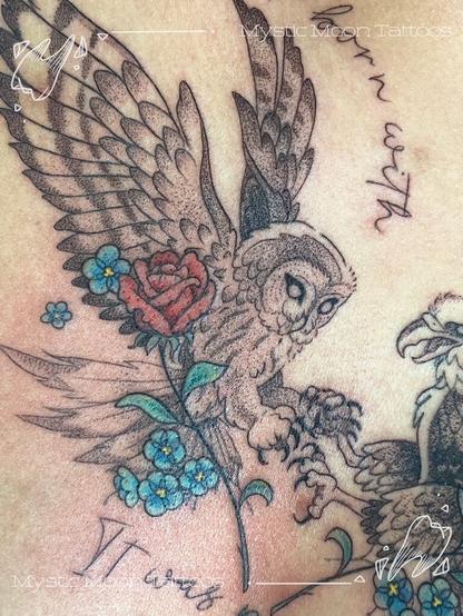 A chest tattoo depicting an owl and an eagle with locked talons, holding flowers, with script reading "You were not born with venom in your veins, it was put there"