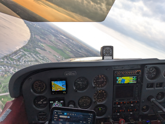 View from inside the cockpit of an airplane in a 30 degree left bank. The instruments are visible and in focus while the outside is tilted and blurry.