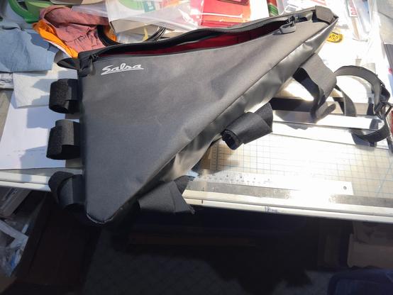 Photo illustrating before shot showing stock straps on Surly Triangle frame pack customization for internal mounting on my Marin Pine Mountain eTrail bike project build.