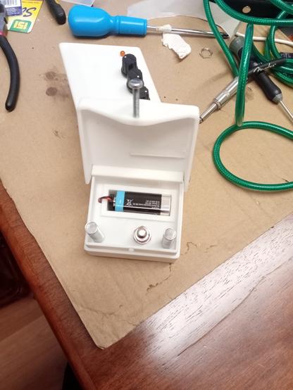 Guitar pedal with the pedal lifted showing the battery connector