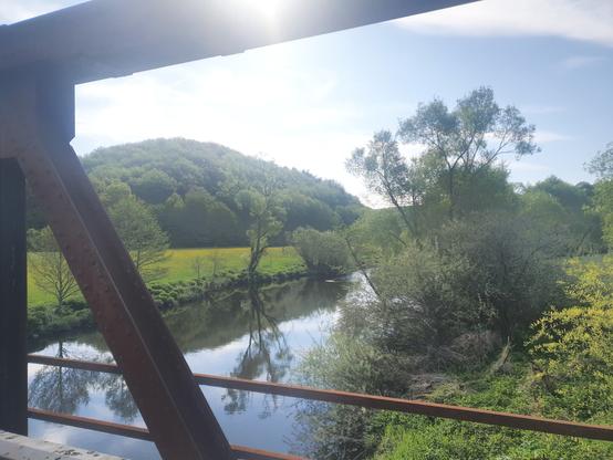 Von einer ehemaligen Eisenbahnbrücke fotografiert. Blick über einen Fluss und jede Menge Hügel.