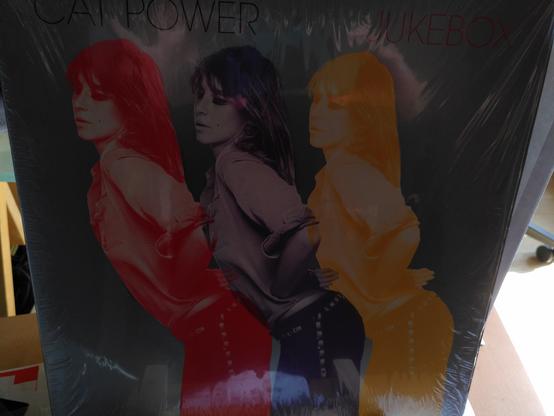 vinyl cover cat power - jukebox
3 photos de la chanteuse dans la même position collées les unes à côté des autres de couleur rouge violet jaune sur fond gris