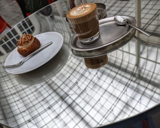 mirrored table with a coffee and cake on plates, mirroring the ceiling abov