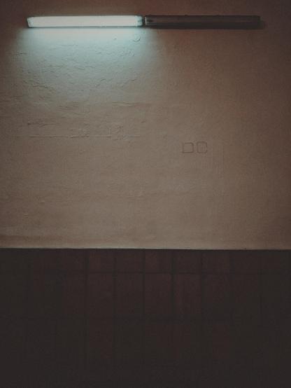 Two lamps next to each other on a station wall. The one on the left works, the one on the right remains dark.