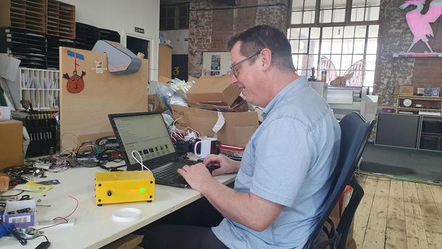 Sitting at his desk in DoES Liverpool, Chris updates a yellow Museum in a Box
