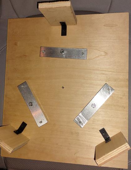 This mirror cell distributes the mirror's weight across 6 points, divided up into three bars that are loose and can pivot to redistribute the weight. When vertical it rests on two wooden blocks at bottom - better mirror cells have more