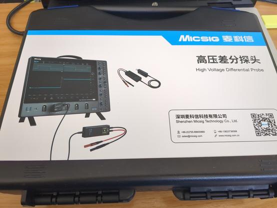 Top of the high voltage probe casing, showing the branding (Micsig) and the probe along with one of their scopes.