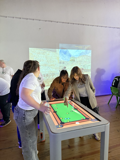 Pertsona batzuk tablet erraldoi baten inguruan joku batera jolasten.