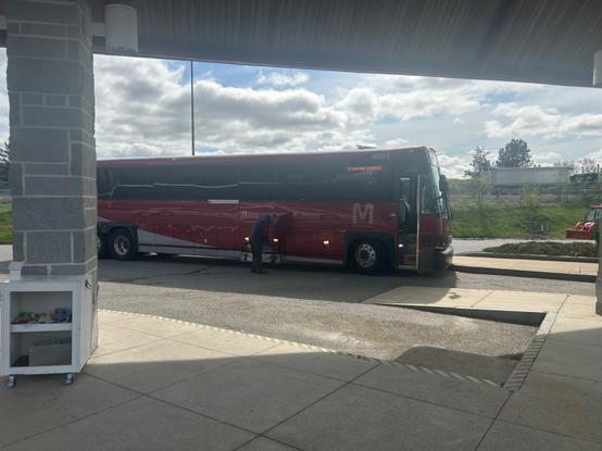 red and silver manchester transit authority coach bus parked at a berth at the concord coach lines terminal in concord