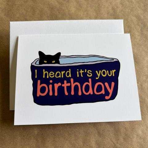 an original art blank inside card by AnneArchy with original art of a black cat peering out of a high-walled cat bed, with hand lettering of the words "I heard it's your birthday"