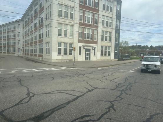 view of the bus making the turn from winter st to church st in laconia, the furthest north point of the route. there’s a converted mill building on the corner of the street.