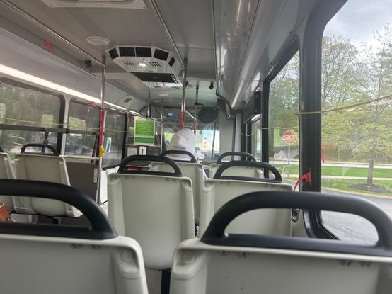interior of the white interior of the very long truck minibus, showing the low floor section with longitudinal seats in the front