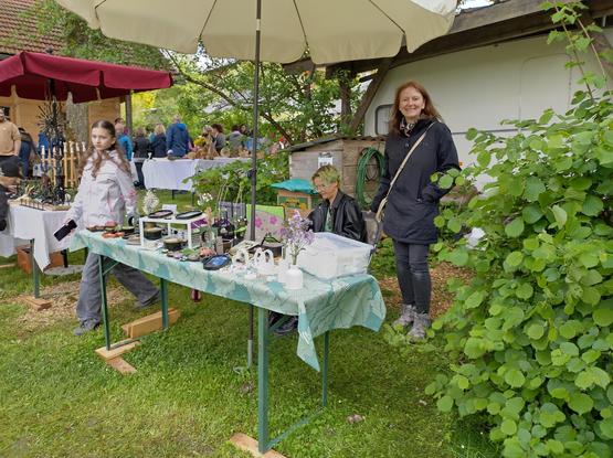 Marktstand mit Kunsthandwerk und Kunsthandwerkerin.