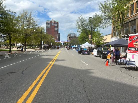 view north on elm st from the center of the street. various stalls and food trucks are set up on the sides of the streets, and a few people are milling around