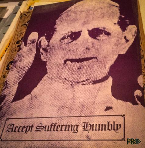 A monochrome poster in purple and pink of a Pope with an inviting hand gesture. Text in a box in the lower part of the text: Accept Suffering Humbly.