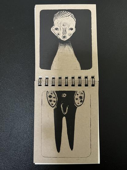 Vertical spiral notebook, laid flat to reveal the front and back covers. It’s a continuous illustration of an artistic variation of a human. It’s intentionally disproportionate and misshapen as artistic style. The art is solid black on a natural brown paper.