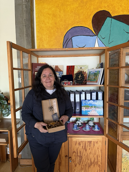 Margarete Rodrigues eguzkilore oparia eskuan, Erasmus+ ko opari guztiak apalean ditu.