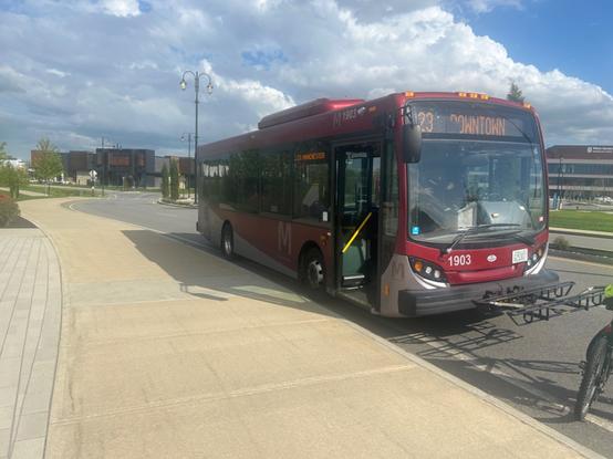 the red mta midi stopped at the strange land of tuscan village, signed for downtown manchester