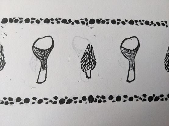 A printed pattern repeating carved images of morel and chanterelle mushrooms bordered on the top and bottom by bands of small circles of varying size.