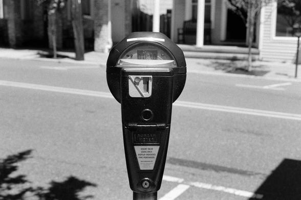 A parking meter next to an empty parking spot