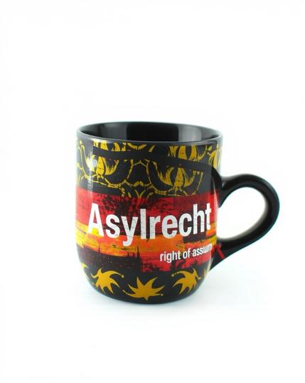 Zu sehen ist eine weiße Aufschrift ‚Asylrecht’ auf einer Tasse in Becherform, die mit einem freien Farbmuster aus Rot und Goldgelb auf schwarzer gestaltet ist. Der Hintergrund des Bildes ist weiß.