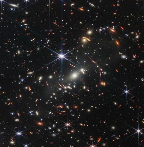 A photo of countless colorful galaxies sprinkled against the vast black background of space. Taken from an article about the James Webb Telescope.