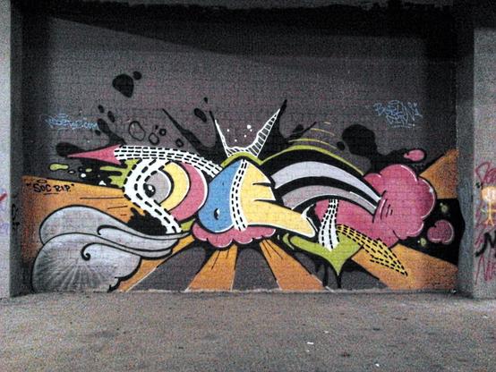 Foto eines abstrakten Graffio in einer sehr dunklen Nische in der Dauerscheinbaustelle der Ruine des Ihmezentrums in Hannover-Linden.