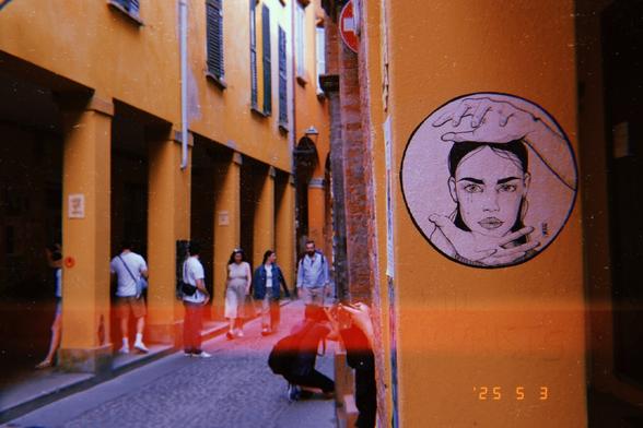 This striking street art features a person's head encircled by hands, creating a sense of framing or focus. It sits on a yellow wall in an alleyway, adding to the urban vibrancy of the scene. The artist's signature, "LA FEE," suggests a connection to their unique artistic vision.

Symbolically, the piece might represent mindfulness, contemplation, or the power of thought. The way the hands frame the head gives the impression of concentration or guidance—perhaps emphasizing introspection or the importance of mental clarity.
