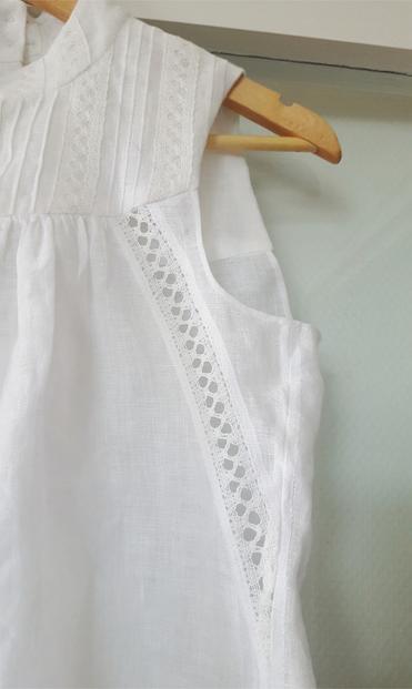 Detail photo of the insertion lace, side seam, arm opening and yoke. The seam allowances have been felled down by hand, the tiny hand stitches showing through to the right side. The insertion lace is between two hemmed and machine top stitched sections, looking sharp and reasonably robust for being on the bias and lace that is mostly air with some ambitions of linen thread. The armhole has been hemmed with a truly tiny rolled hem, also by hand.