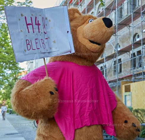 Person in Bären-Kostum mit einem Schild: "H48 bleibt".