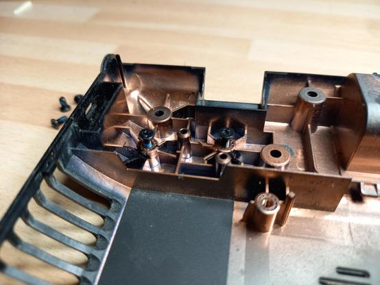 Linke hintere Ecke der Laptop Bodenplatte mit 2 frisch eingeklebten Schraubtüllen.