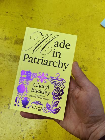 Cover of the booklet. Yellow with black print and purple shiny foil.
