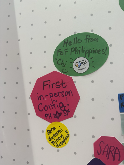 Three stickies on a wall made to look like the FigJam canvas with the dotted effect. The first sticky is a green circle with the Friends of Figma Philippines logo and 'Hello from FoF Philippines! - Chi :)' written on it. The second sticky is found to the bottom left of the first and is a fuschia hexagon that reads 'First in-person Config!' and PH and SF are separated with an airplane emoji drawing. The last sticky is a yellow circle found at the bottom of the previous one which reads 'Sana dumami Pinoy designers!'.