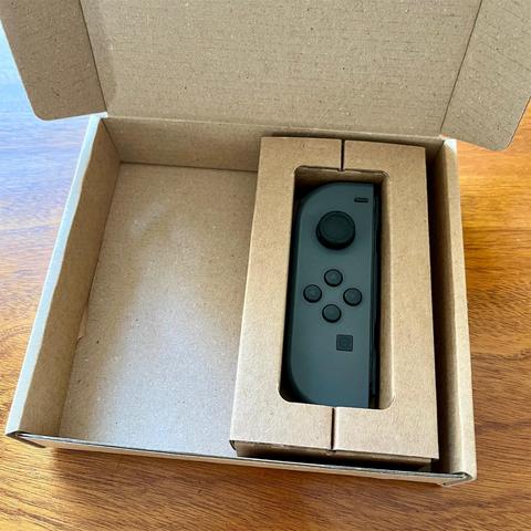 A lonely joycon controller in a cardboard box