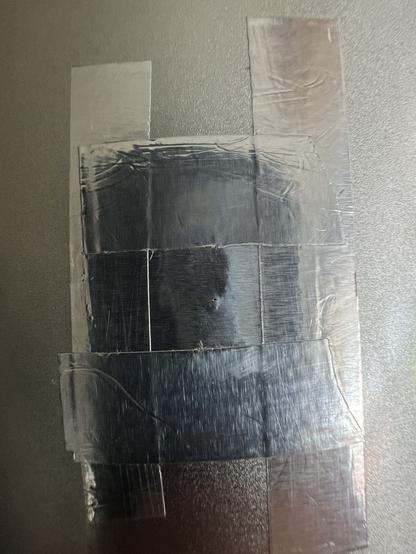 Detailed view of the tiny hole in the aluminum foil taped to the outside of the can. Diameter is measured at around 0.2mm.