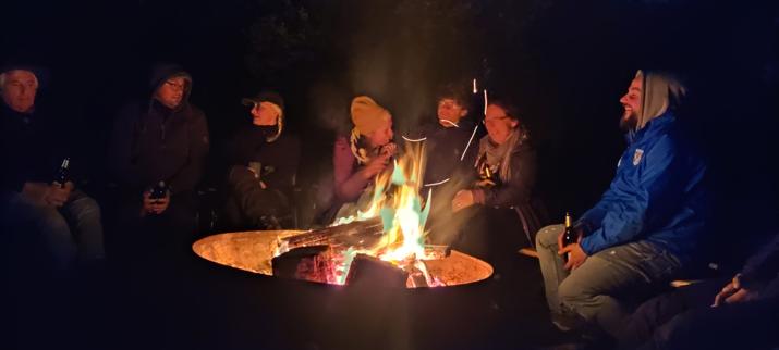 Mensch bei Nacht hinter einem Lagerfeuer